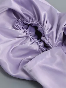 Vista macro de los elegantes detalles de volantes de satén púrpura en un vestido