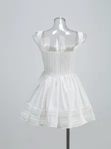 Back detail view of a white sleeveless mini dress featuring a pleated hem and zipper closure