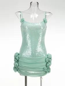 Detailopname van mintgroene paillettenjurk met spaghettibandjes en elegante 3D-bloemen.