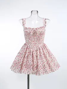 Detailed shot of a floral mini dress with ruffled neckline and bow tie on a mannequin