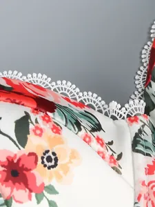 Macro view showing the intricate white lace trim on a vibrant floral printed dress