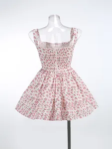 Back view of a summer floral mini dress with smocked elastic details on a mannequin