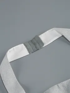 Dettaglio della chiusura a gancio regolabile su un vestito da festa glitterato argento
