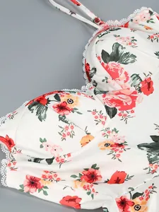Detailed macro shot of the red floral pattern and white lace trim on a mesh strap dress