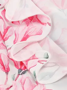 Close-up of pink floral pattern and elegant ruffle detail on a summer chiffon dress