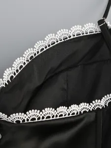 Detailed view of elegant white scalloped lace trim on a black mesh party dress bodice.