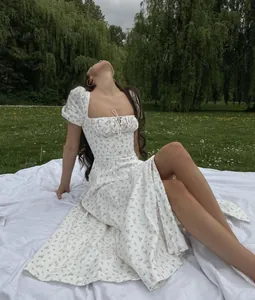 Detail of a white French floral dress featuring puff sleeves and tie-front bodice.