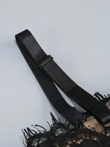 Close-up of adjustable black strap and delicate lace detail on a sexy mesh evening dress.