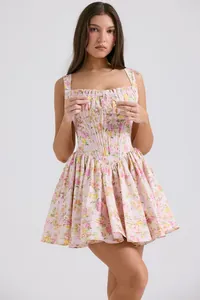 Detailed view of pink floral mini dress with corset bodice and pleated flared skirt