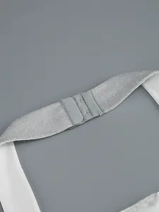 Dettaglio dell'abito bianco allacciato al collo con cinturino argento e ganci chiusura