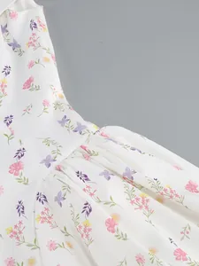 Close-up detail of an elegant white floral off-the-shoulder dress showing intricate pleat texture