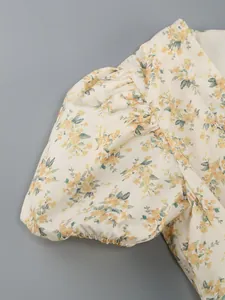 Macro view of the puff sleeve detail with yellow floral print on a summer dress