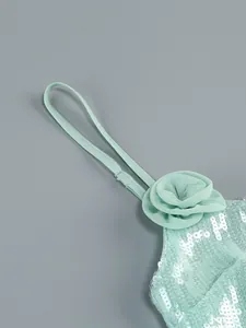 Macro-detail van een mintgroene paillettenjurk met elegante chiffon bloemversiering