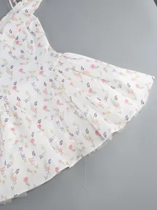 Detailed view of the elegant white floral puffy dress with pleats and print texture