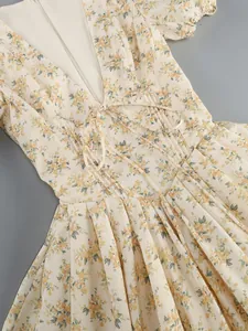 Detailed macro shot of vintage floral dress with deep V-neck and delicate waist tie