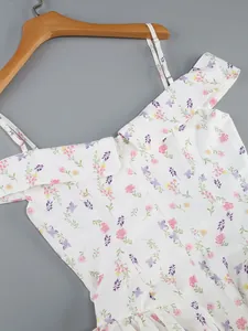 Macro view of white floral off-the-shoulder dress featuring thin straps and ruffles