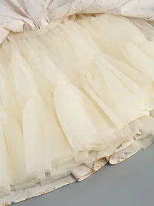 Detailed view of the multi-layered cream tulle petticoat underneath a floral print dress