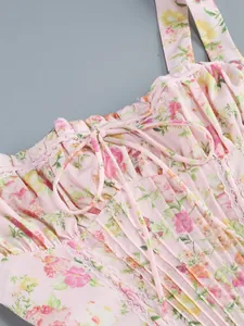 Detailed close-up of a pink floral strap dress with delicate lace trim and pleated bust area