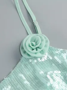 Detail van een mintgroene paillettenjurk met een chiffon bloem op de schouderband