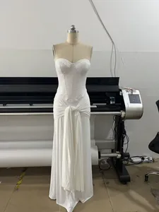 Detailed view of the white sequin bodice and pleated waist on a floor-length evening dress.