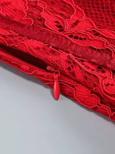 Close-up detail of a matching red invisible zipper on elegant floral lace dress fabric