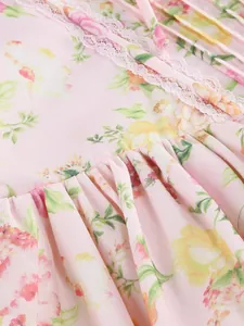 Close-up detail of soft pink floral printed fabric featuring delicate lace trim and ruffles.