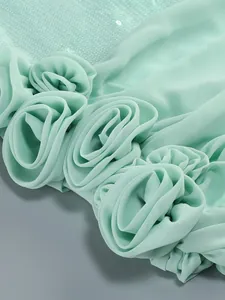 Gedetailleerd overzicht van mintgroene jurk met handgemaakte 3D-bloemen en lovertjes