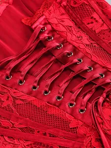 Close-up detail of elegant red lace dress with satin ribbon lacing and metal eyelets