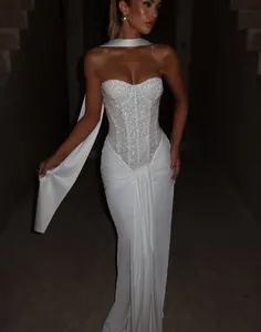 Detail view of a white sequin strapless evening gown with elegant draped pleats.