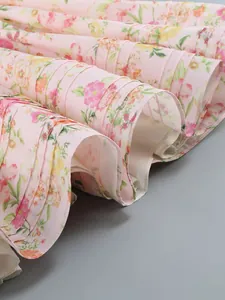 Detailed close-up of pink floral dress hem showing delicate pleats and fabric texture.