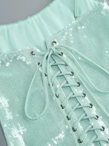 Close-up van mintgroene paillettenjurk met elegant veterdetail op de rug