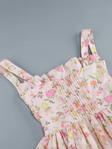 Close-up detail of a pink floral summer dress featuring a pleated bodice and thin straps