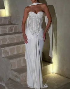 Full-length view of an elegant white strapless sequined bodice evening gown with draped skirt detail