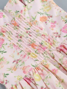 Close-up detail of pink floral dress featuring elegant pleats and ruched fabric