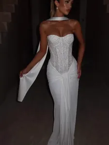 Close-up detail of white sequined strapless evening gown with draped scarf