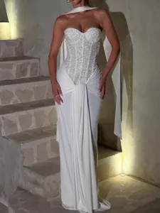 Elegant white strapless evening gown with sequined corset and draped skirt detail