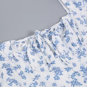 Close-up of ruffled square neckline and tie-front detail on blue floral white dress