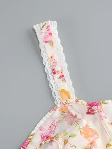 Close-up of elegant floral print dress showing delicate white lace trim on the straps.