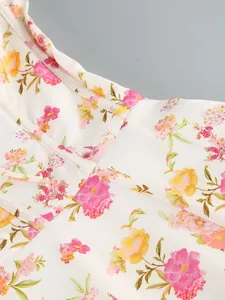 Macro view showing the vibrant pink and orange floral print on a white midi dress fabric