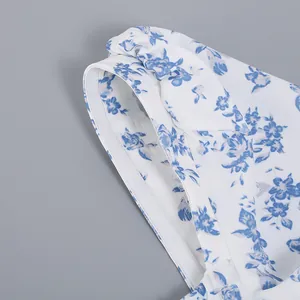 Close-up of blue floral pattern and bow detail on a white summer dress
