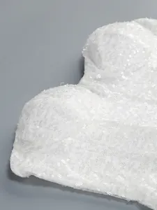 Detailed macro shot of white sequins on an elegant strapless evening gown bodice.