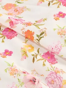 Close-up of elegant pink and orange floral print fabric texture on white dress