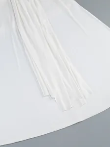 Close-up detail of the elegant white pleated hemline on this slim fit maxi evening dress.