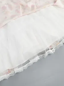 Detail of a floral print dress hemline featuring delicate lace and white mesh lining.