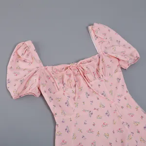 Detailed macro view of a pink French floral dress featuring a square neck and tie