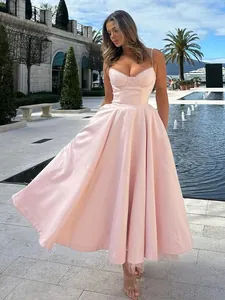 Detail view of a pale pink spaghetti strap prom dress with a voluminous A-line skirt.