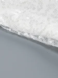 Close-up detail of high-quality white sequins on a elegant mesh evening dress fabric
