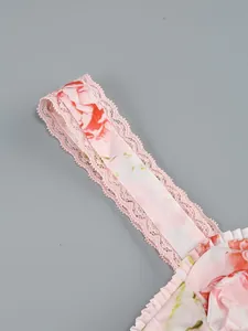 Close-up of pink floral print strap with delicate lace trim on elegant dress