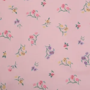 Close-up of delicate pink floral print fabric texture for a vintage French-style summer dress