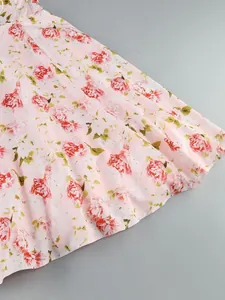 Macro view showing the elegant red peony floral print on pink midi dress fabric detail